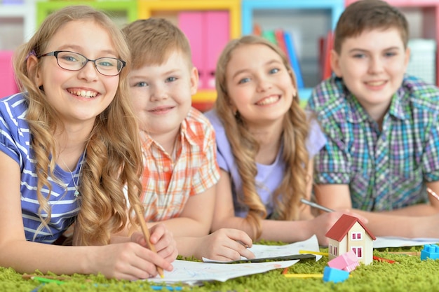 Kinderen liggend op de vloer tekenen met potloden