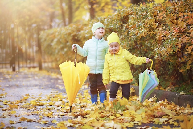 Kinderen lopen in de herfst in het herfstpark