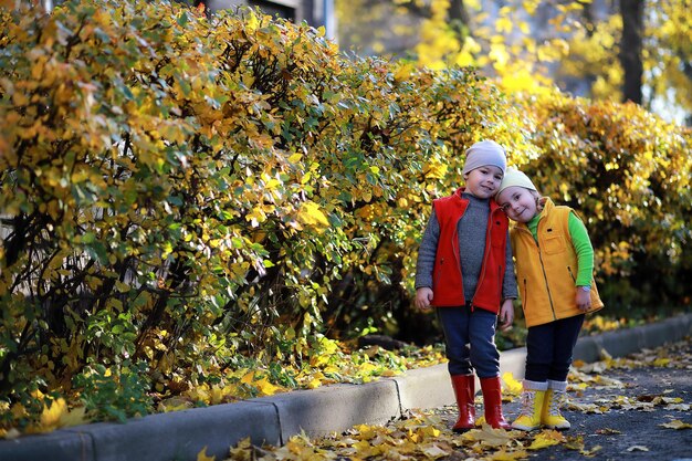 Kinderen lopen in de herfst in het herfstpark