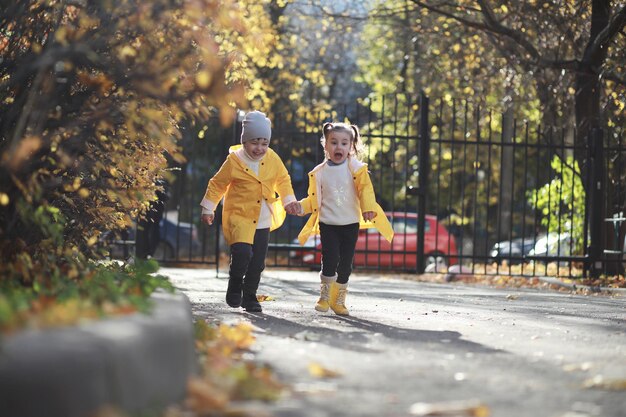 Kinderen lopen in de herfst in het herfstpark