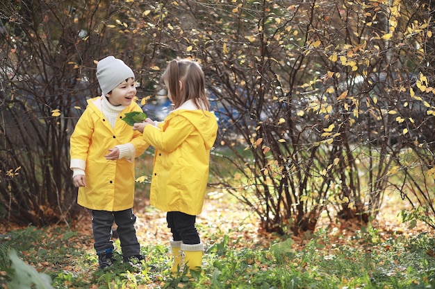 Kinderen lopen in de herfst in het herfstpark