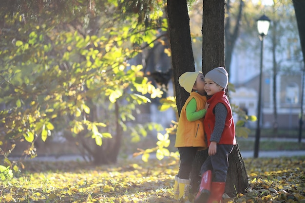 Kinderen lopen in de herfst in het herfstpark