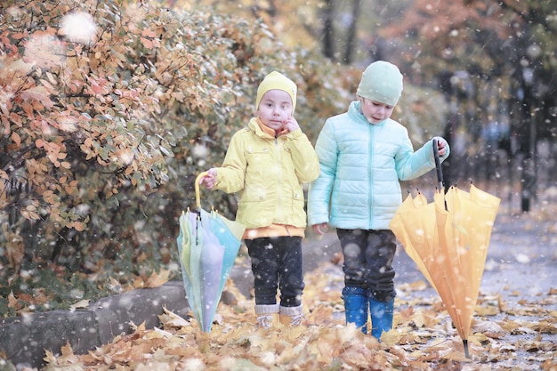 Kinderen lopen in het park eerste sneeuw