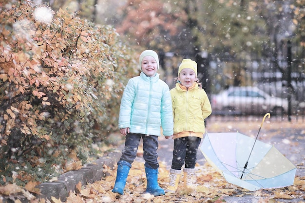 Kinderen lopen in het park eerste sneeuw