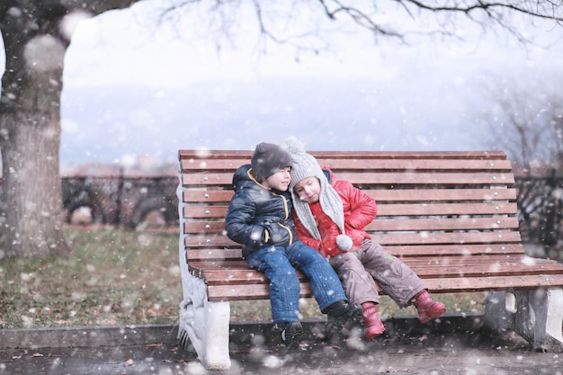 Kinderen lopen in het park eerste sneeuw