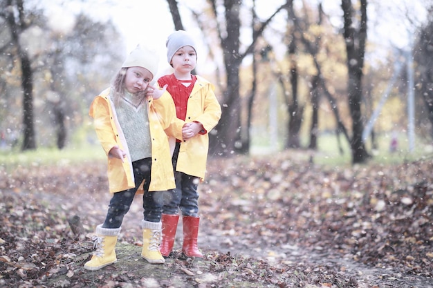 Kinderen lopen in het park met de eerste sneeuw