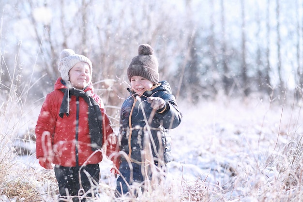 Kinderen lopen in het park met de eerste sneeuw