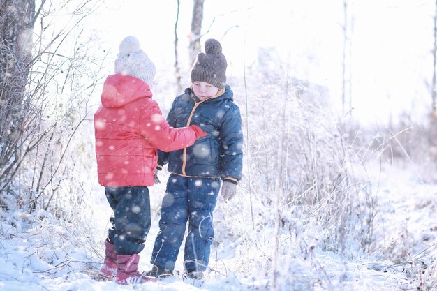 Kinderen lopen in het park met eerste sneeuw