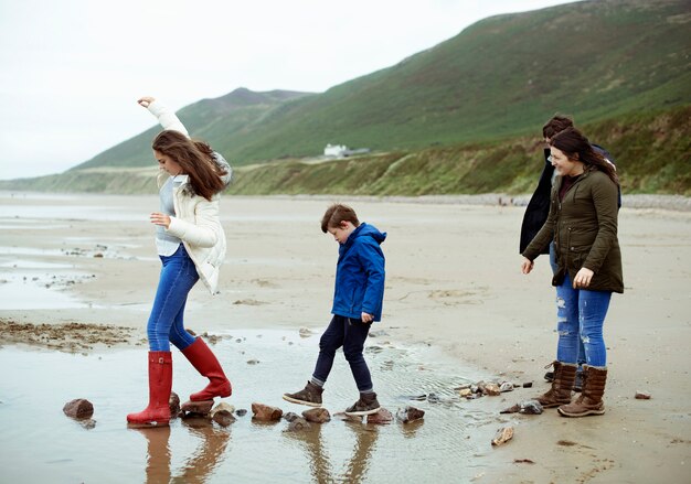 Kinderen lopen op stenen op het strand