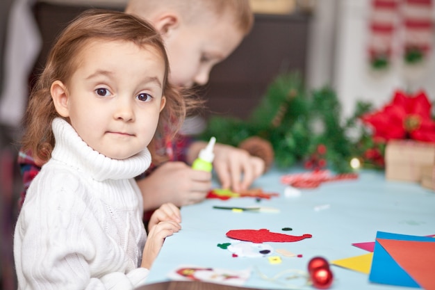 Kinderen maken decor voor kerstboom of cadeaus.