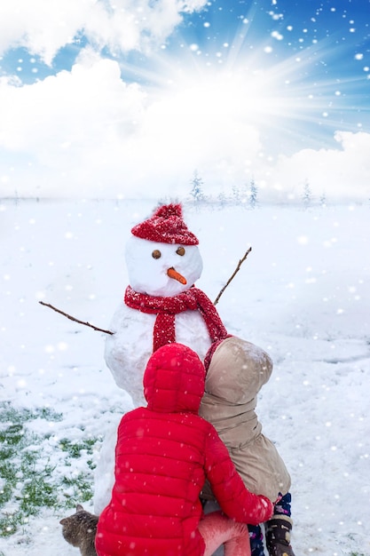 Kinderen maken een sneeuwpop in de winter Selectieve aandacht