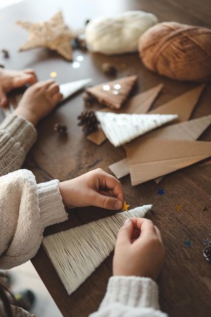 Kinderen maken kerstversieringen van garen