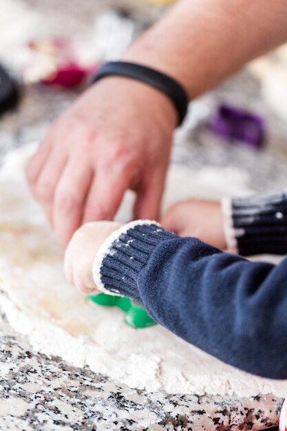 Kinderen maken koekjes met familie voor kerstmis.