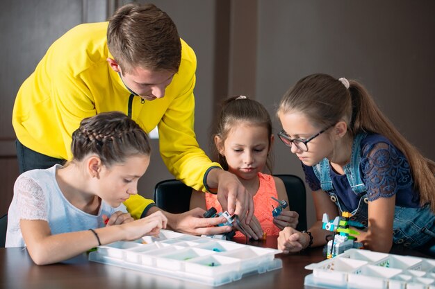 Kinderen maken robots met leraar. vroege ontwikkeling, diy, innovatie, moderne technologie.