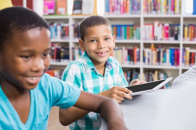 Kinderen met behulp van digitale tablet in de bibliotheek