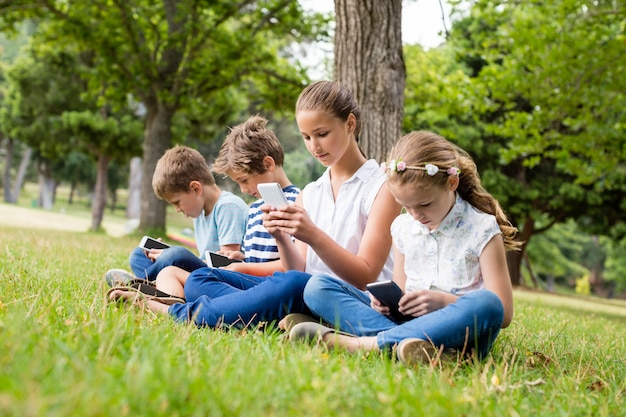 Kinderen met behulp van mobiele telefoon in park