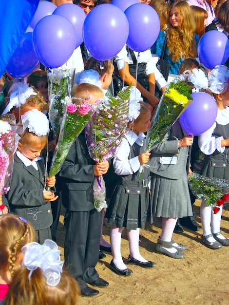 Foto kinderen met bloemen en ballonnen op een feestdag van 1 september