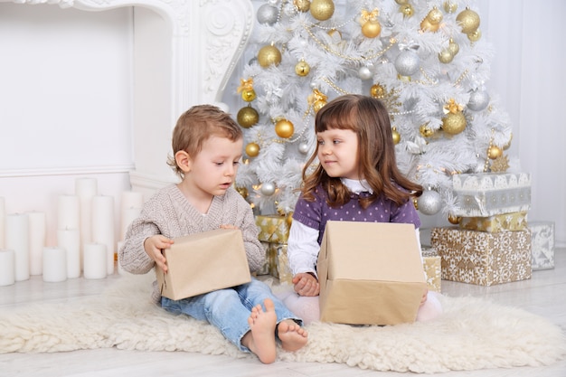 Kinderen met cadeautjes onder de kerstboom