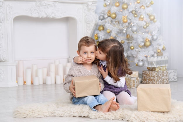 Kinderen met cadeautjes onder de kerstboom