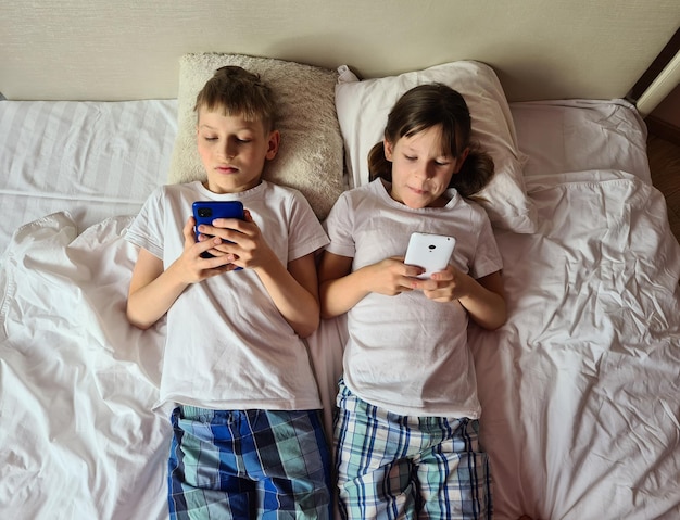 Kinderen met gadget smartphones smartphones in bed thuis
