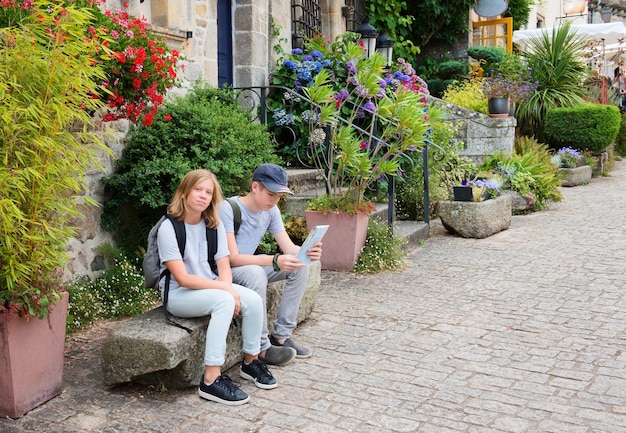 Kinderen met kaart die in de straat van een oude stad van Europa reizen