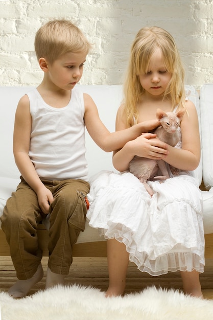 Kinderen met kitten bij daglicht thuis