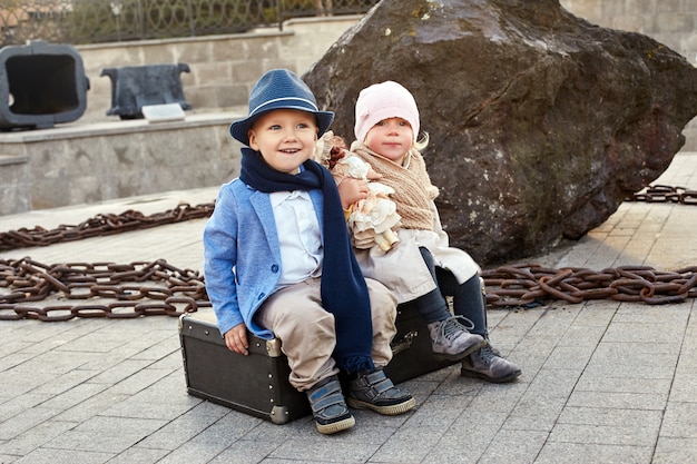 Kinderen met koffers reizen, retro herfst lente kleding