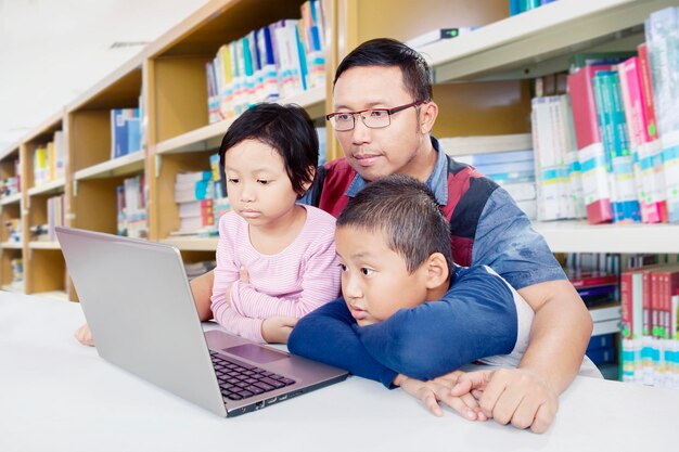 Kinderen observeren hun vader die lesgeeft in de bibliotheek