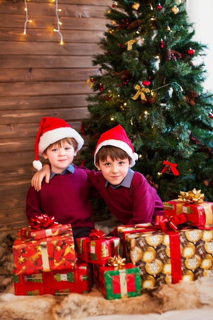 Kinderen onder de kerstboom met geschenkdozen