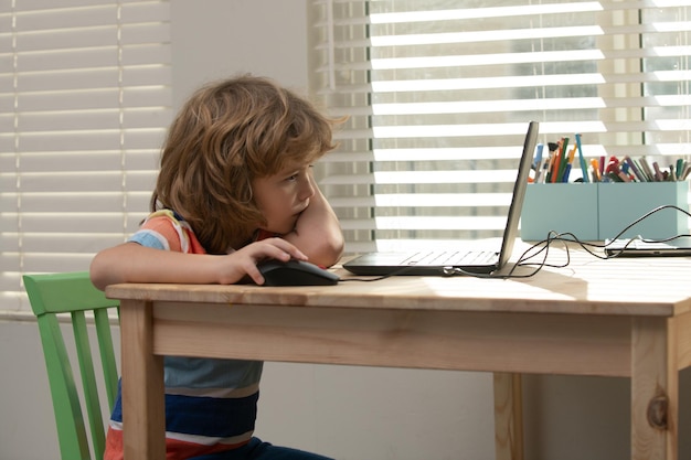 Kinderen onderwijs en studie concept portret van schooljongen kijken naar de laptop tijdens de les eerste da