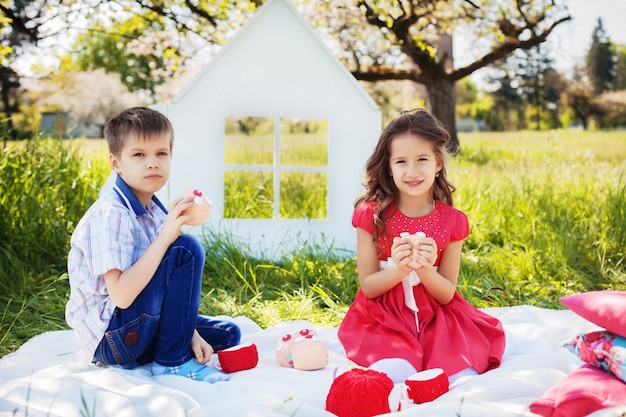 Kinderen op een picknick in de weelderige tuin. Het concept van kindertijd en levensstijl.