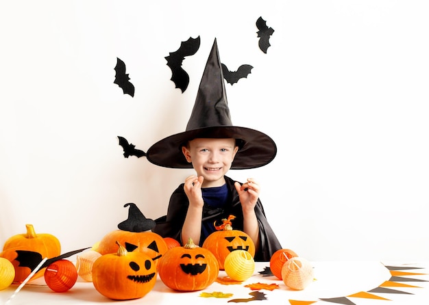 Kinderen op Halloween Grappige kleine jongen in een heksenhoed met pompoenen Happy Halloween