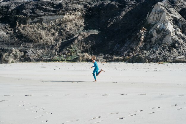 kinderen op het strand, op de oceaan, joggen voordat ze surfen