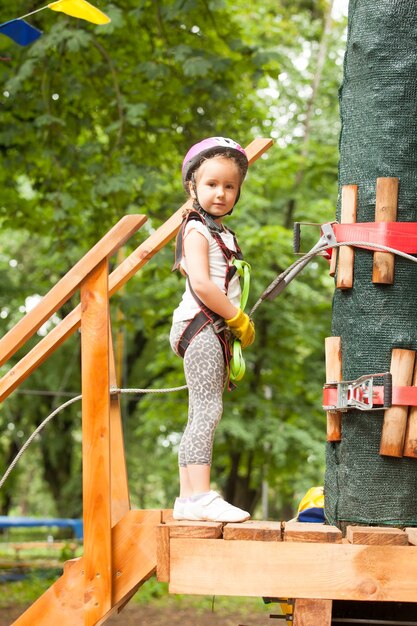 Kinderen op hindernisbaan in avonturenpark in berghelm en veiligheidsuitrusting