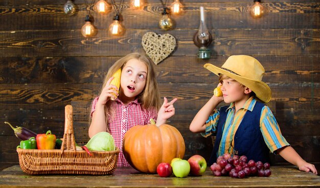 Kinderen presenteren boerderij oogst houten achtergrond. Familie boerderij. Redenen waarom elk kind landbouw zou moeten ervaren. Verantwoordelijk voor de dagelijkse werkzaamheden op de boerderij. Kinderen boeren meisje jongen groenten oogst.