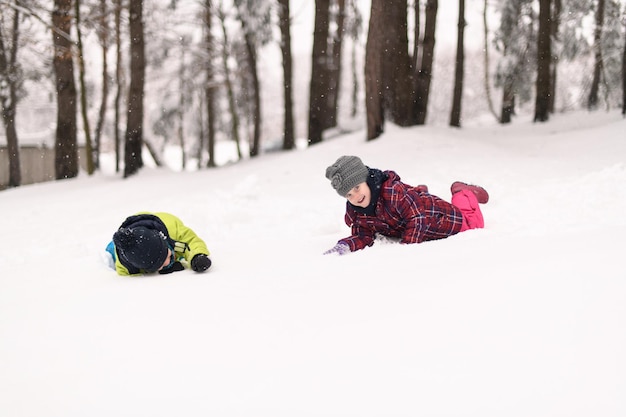 Foto kinderen rennen en spelen in het winterbos