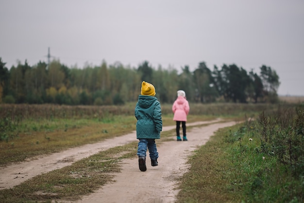 Kinderen rennen het veld in. Kinderen spelen in het veld rennend van vliegende drone