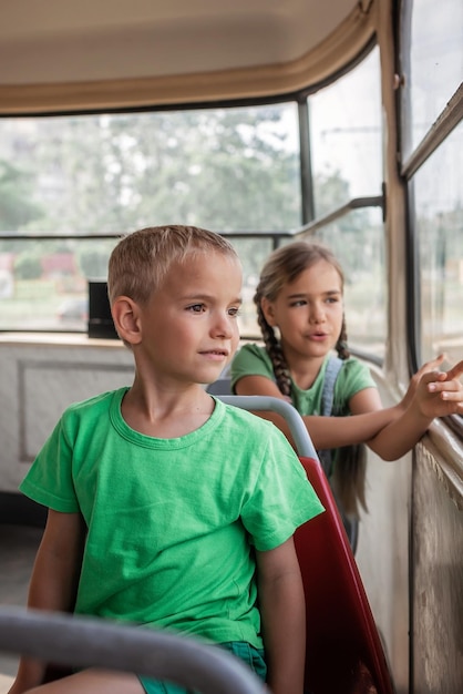 Kinderen rijden in lege tram en kijken naar het raam met interesse openbaar vervoer stadstram