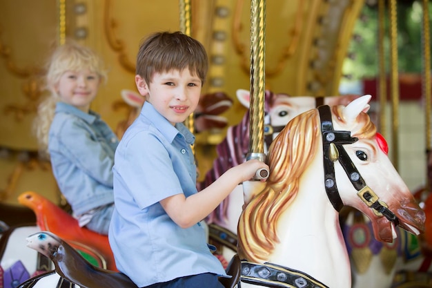 Kinderen rijden op een retro paardencarrousel