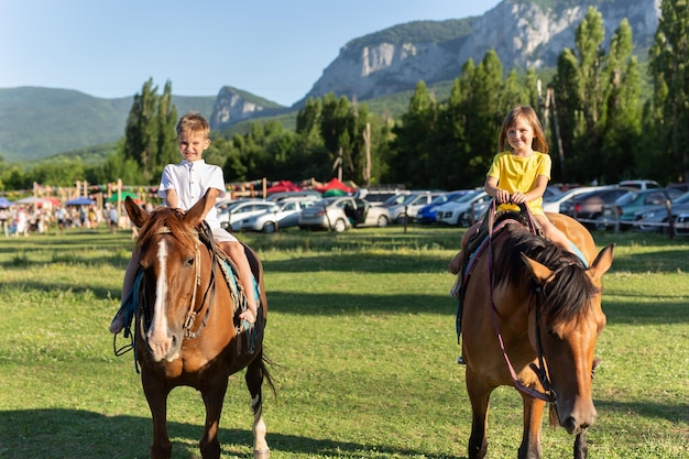 Kinderen rijden paard op de kermis met uitzicht op de bergen