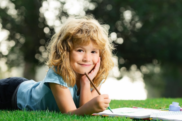 Kinderen schilderen in de lente natuur kinderen schilderen met verf kleur en penseel in park buiten