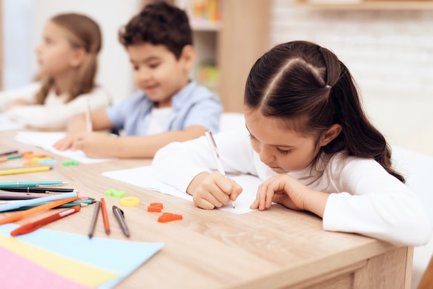 Kinderen schrijven in notitieboekjes met een pen.