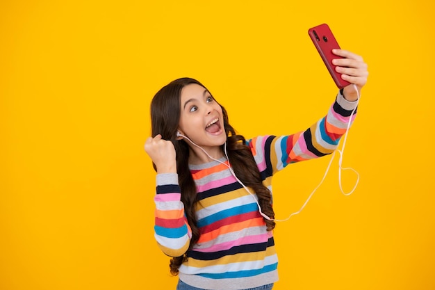 Kinderen selfie Verbaasd tiener kind meisje met smartphone Hipster meisje typt tekstbericht op mobiele telefoon geniet van online communicatie typen feedback