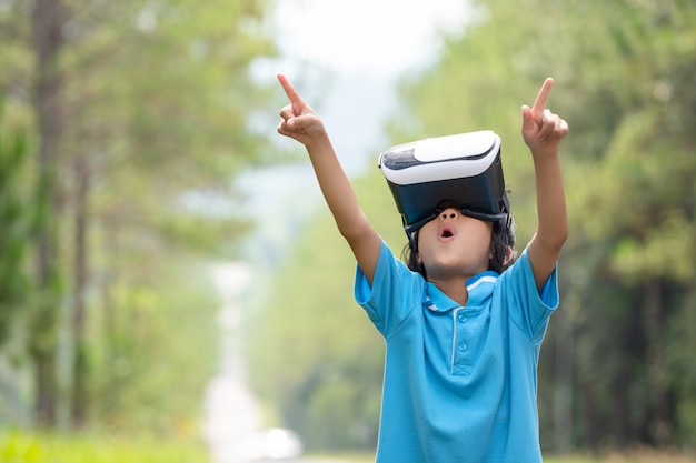 Kinderen spannende kijken naar virtual reality box bril op wazig boom