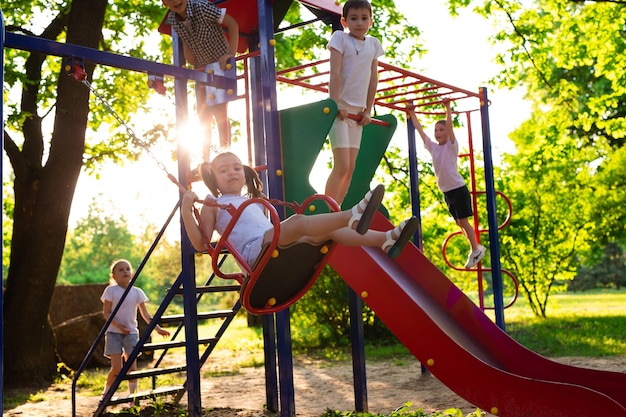 Kinderen spelen buiten, rennen en hebben plezier in een park met de natuur eromheen