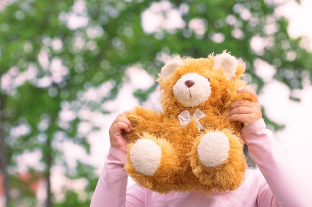 kinderen spelen een teddybeer op handen