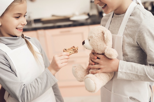 Kinderen spelen in de keuken Geef koekje aan een teddybeer.