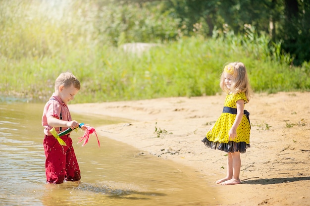 Kinderen spelen in de rivier met boten