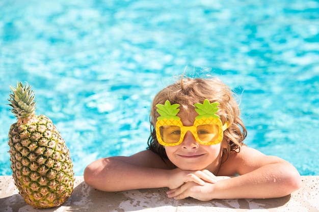 Kinderen spelen in een tropisch resort Klein jongenskind dat plezier heeft in het zwembad Zomerananasfruit