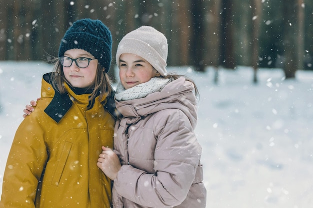 Kinderen spelen in het besneeuwde bos Peuterkinderen buiten in de winter Vrienden spelen in de sneeuw Kerstvakantie voor gezin met jonge kinderen